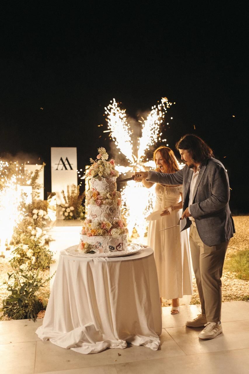 Cake-cutting moment with sparkler fountains at night